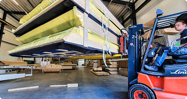 Prefab dakelementen worden in de hal verplaatst